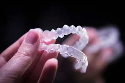 patient holding their new clear aligners they received from Parkview Family Dentistry